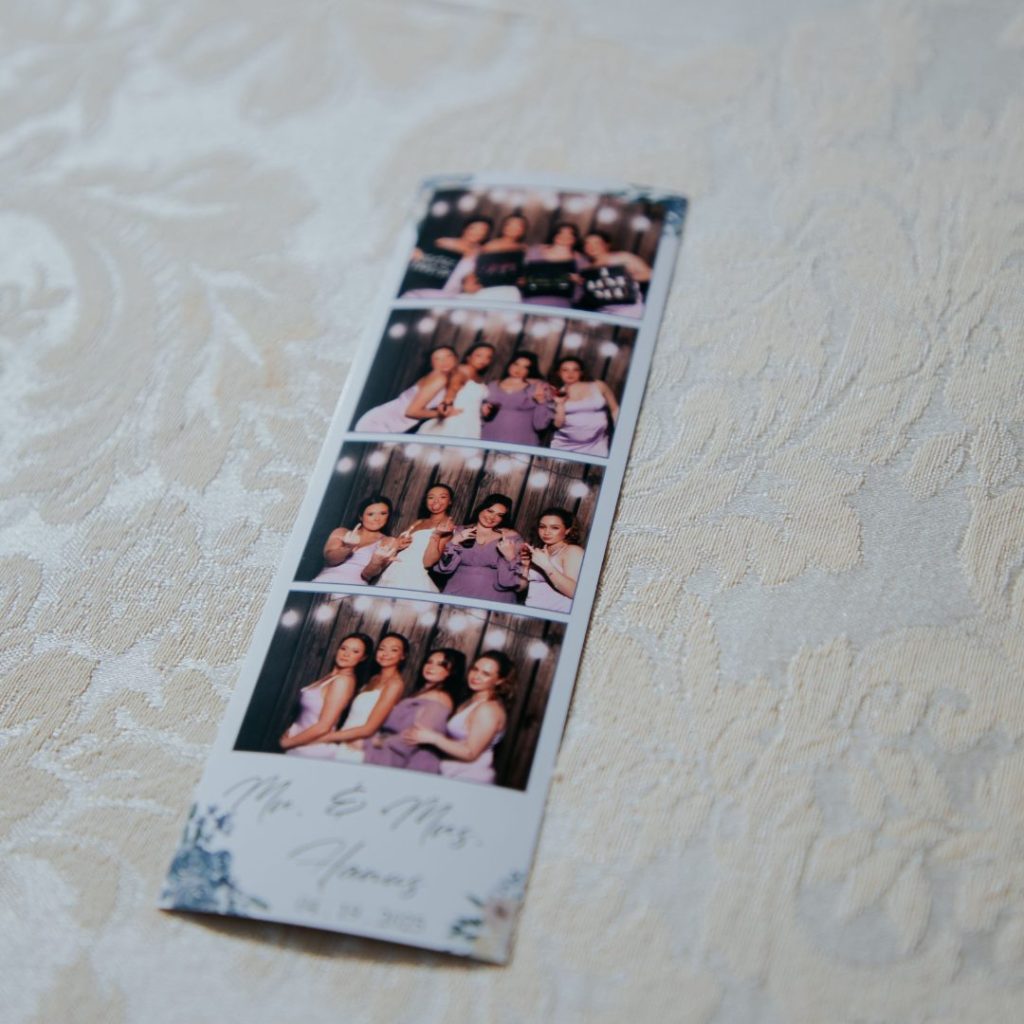 Instant photo booth prints from In The Mix Event Group displayed on a wedding reception table.
